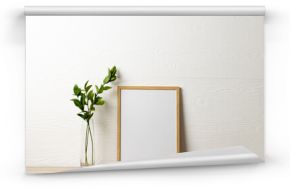 Wood empty frame with copy space and plant on table against white wall