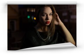 beautiful sexy girl with big lips with red lipstick on a city street at night near the lantern