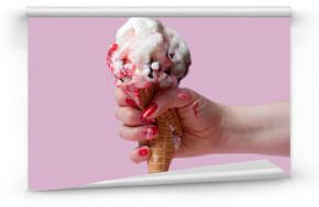 A female hand holds an ice cream cone on a pink background. The ice cream melted and ran down my fingers and hand. The hand squeezed and crushed the waffle glass.