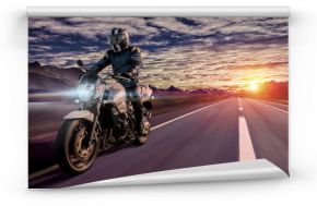 motocyklista jedzie wieczorem do domu autostradą o zachodzie słońca