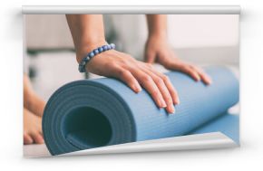 Yoga at home active lifestyle woman rolling exercise mat in living room for morning meditation yoga banner background.