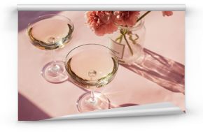 Two glasses of sparkling wine on a pink table
