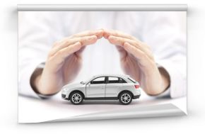 Car insurance. Small silver car covered by hands.