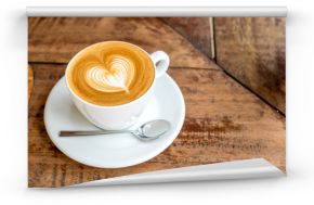 Zamknij się biały kubek kawy z latte art kształcie serca na karcie drewna