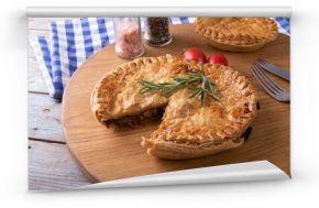 High angle view of baked stuffed pies with rosemary served on serving board at table