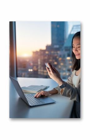 Young happy busy Asian business woman executive using laptop mobile cell phone tech at night in dark office. Professional businesswoman holding smartphone, working on cellphone with Generative AI