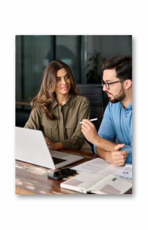 Middle aged female manager teaching young male worker looking at computer discussing ai online business software at office meeting. Two busy colleagues working together talking using laptop in office.