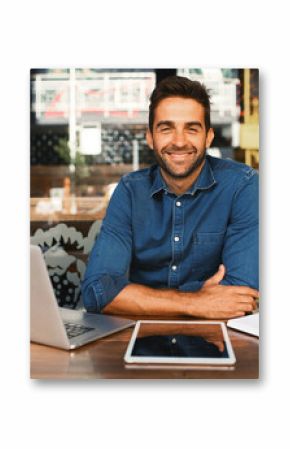Laptop, portrait and tablet with man in coffee shop to research for small business startup. Computer, remote work and website with happy freelance employee person at cafe or restaurant as customer
