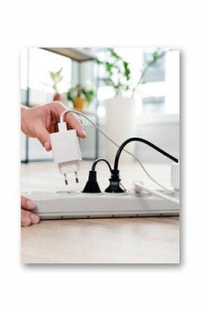 Person is plugging in a device to a power strip