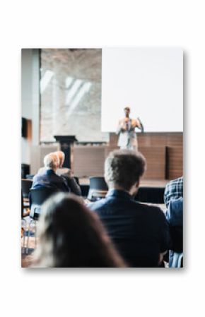 Speaker giving a talk in conference hall at business event. Rear view of unrecognizable people in audience at the conference hall. Business and entrepreneurship concept
