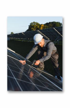 Man worker mounting photovoltaic solar panels. Engineer in helmet installing solar module system. Concept of alternative, renewable energy