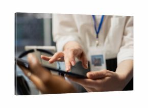 Close up of data center engineering team using tablet to inspect gear, doing maintenance tasks. Server farm coworkers using device to conduct system checks on network rigs