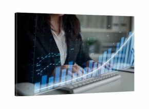 A focused businesswoman in a black suit analyzes data insights using a computer with financial graphs. The scene captures a modern office environment dedicated to success. Copula