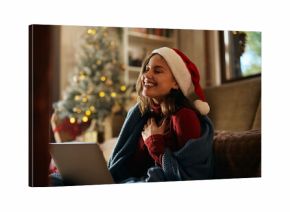 Joyful woman making video call over laptop on Christmas day at home.