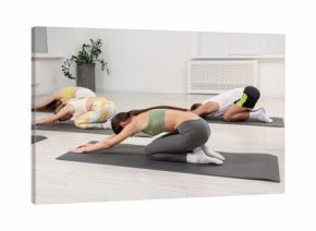 Group of people doing stretching exercise on fitness mats in gym