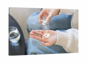 Sick asian young woman, girl holding tablet pill on hand pouring drug from medication bottle, painkiller medicine from stomach pain, head ache, pain for treatment, take drug or vitamin, health care.