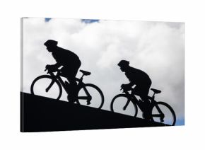 black silhouette of two cyclists ascending a hill against a cloudy sky man riding a bike