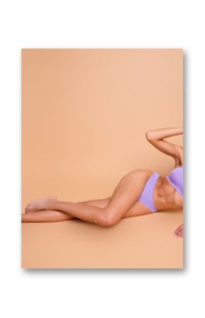 Full body no filter portrait of stunning model girl lying floor posing isolated on beige color background