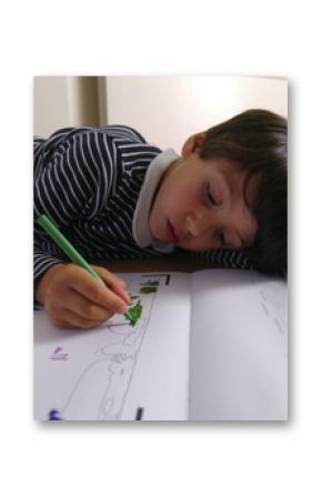 Young boy deeply engaged in drawing with a green pen while lying on the floor, focused on coloring in a book, intense creative concentration, indoor art time