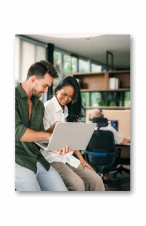 Two happy diverse multiethnic business team people working, talking in corporate office