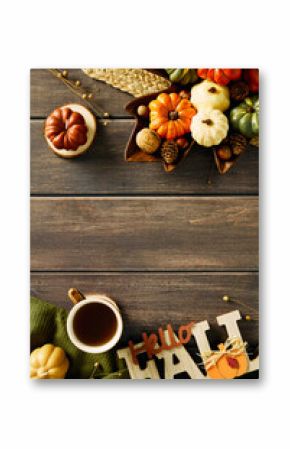 Rustic autumn flat lay with pumpkins, pinecones, berries, and tea mug on wood. Cozy seasonal decor with Hello FALL sign, perfect for fall, harvest, or Thanksgiving