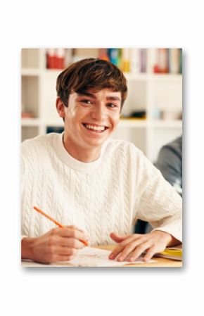 High school student, portrait and writing in classroom for exam assessment, quiz and education. Teenager, boy and happy with aptitude test in lesson for scholarship, learning and curriculum knowledge