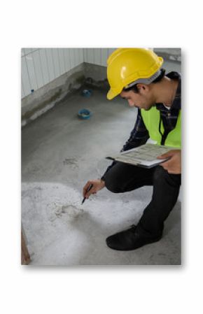 Engineer or inspector using blueprint check sheet examining cracked concrete floor during house construction. Quality control, building inspection, structural defect, real estate maintenance concept.