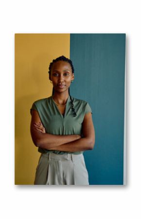 Portrait of African young businesswoman standing arms crossed against colorful wall in office