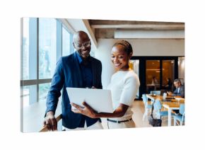 Professionals discussing ideas with a laptop in a bright office space