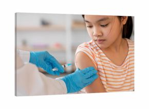 A young girl sits calmly while a healthcare worker administers a vaccine to her arm. The clinic is well-lit and organized, focusing on child healthcare.