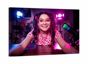 Cheerful female content creator streaming live podcast from home studio with neon lights and colorful background