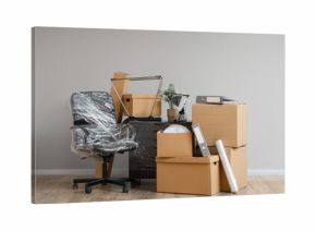 Wrapped furniture with stretch film and moving boxes in office