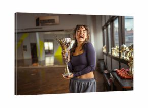 Young woman proudly holding trophy celebrating victory