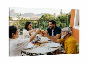 Family toasting to a barbeque meal on a balcony in Rio