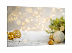 Christmas Holiday background with snow, fir tree and decorations with christmas light behind. Christmas golden balls on a winter festive background.