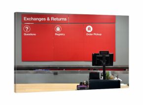 Customer service counter with a red signage board above it for exchanges, returns, questions, registry, and order pickup. The counter has a point-of-sale monitor.