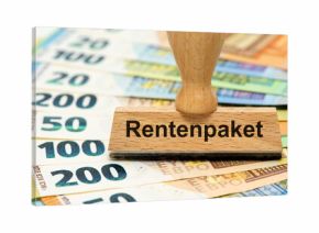 Ein Holzstempel ist beschriftet mit dem Aufdruck Rentenpaket als Symbolbild für Reformen im Rentensystem der Alterssicherung - digital bearbeitet