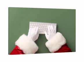 Santa Claus hands with keyboard on green background