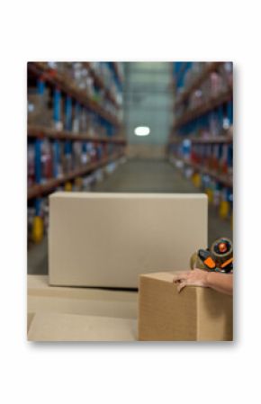 Metal shelving racks holding cardboard boxes and pallets along warehouse aisle under bright lights
