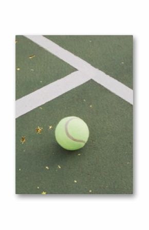 Resting tennis ball on outdoor tennis court near white lines, with gold star confetti, copy space