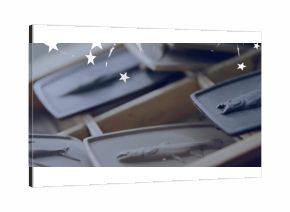 Placing grey tray showcasing fish relief on rack at studio, copy space with star-shaped overlays
