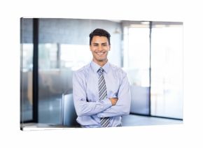 Glass partitions dividing bright open office, overhead lights shining through frosted panels