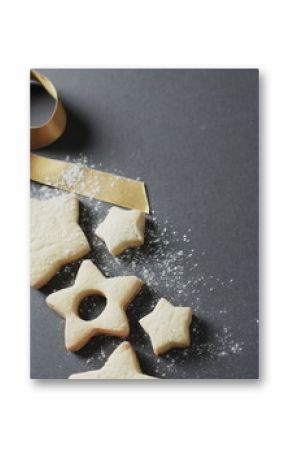 Golden ribbon adorns star-shaped cookies on a dark surface