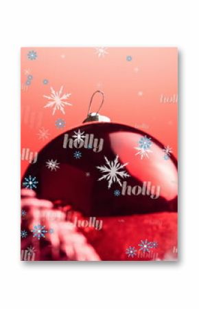 Displaying Christmas bauble on tabletop, glittery star, coiled ribbon, snowflake and holly text