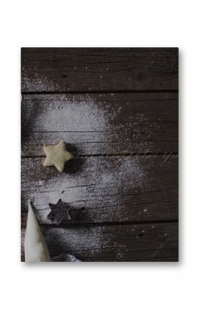 Star-shaped cookies and cutters on a dark wooden table, with copy space