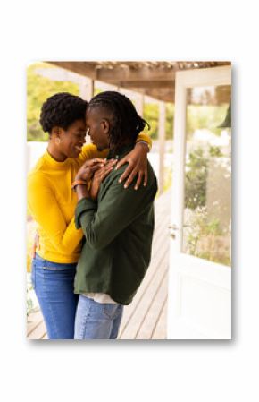 Embracing lovingly on porch, African American couple enjoying intimate moment together