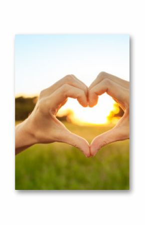 Beautiful hand shaped heart against colorful sunset. 