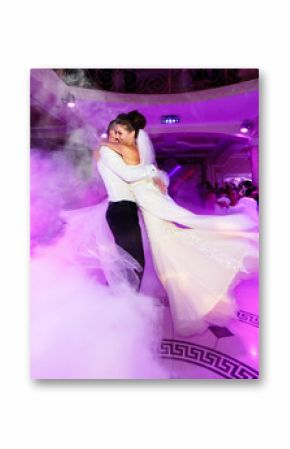 Pink light illuminates wedding couple dancing in the smoke