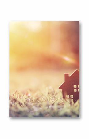Skopiuj przestrzeń koncepcji domu i życia. Małego modela dom na zielonej trawie z światło słoneczne abstrakta tłem.