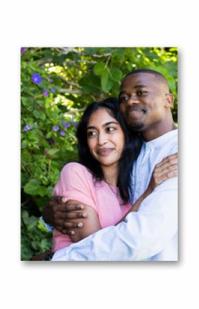 Couple embracing in garden, enjoying romantic moment surrounded by lush greenery
